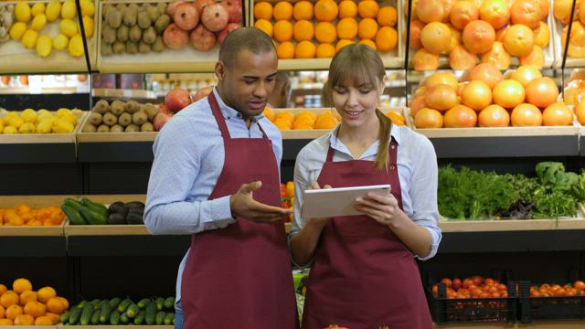 Grocery store staff with a tablet.
