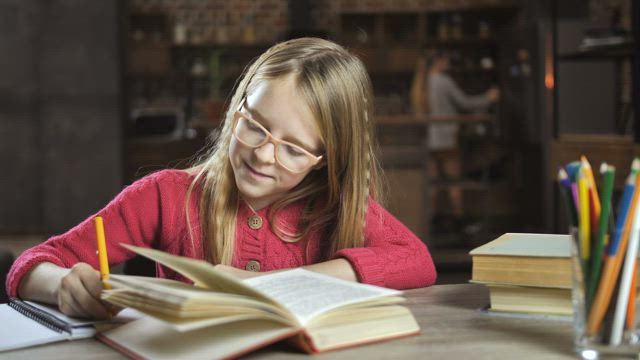 Happy child doing her homework.