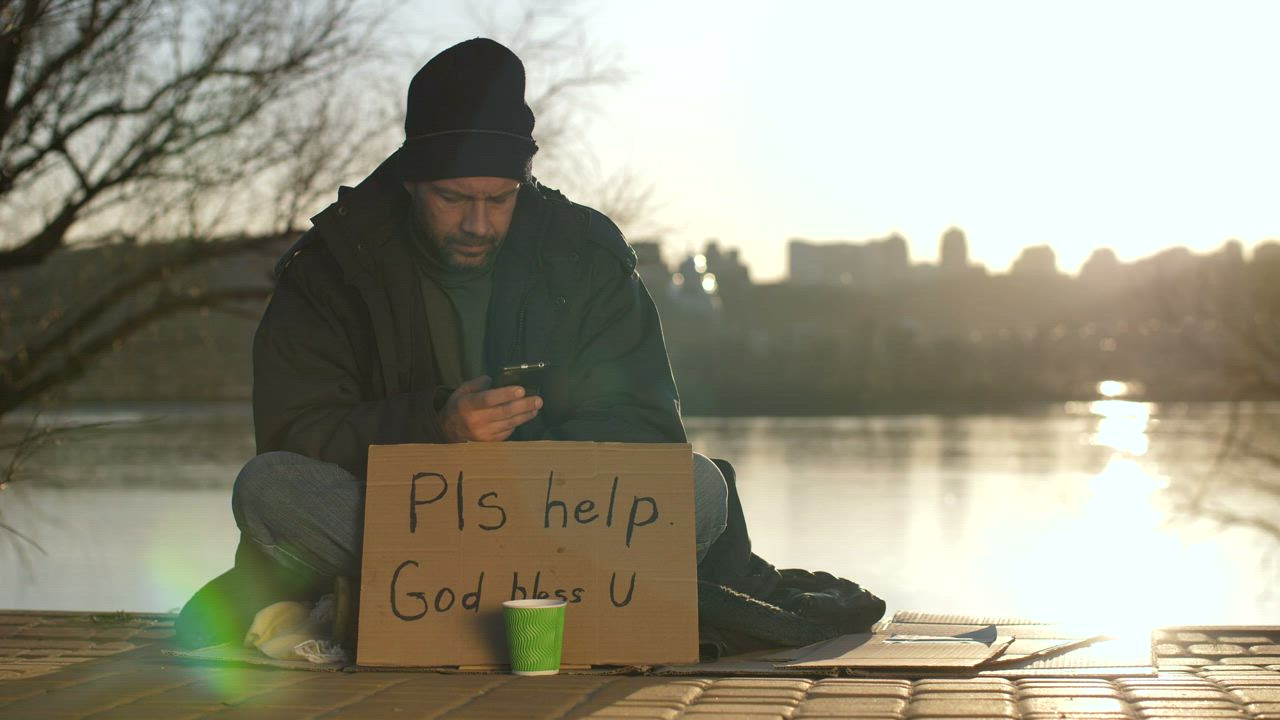 Homeless man with a smartphone - Free Stock Video