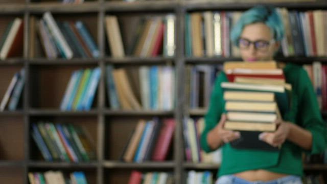 Woman carrying a lot of books.