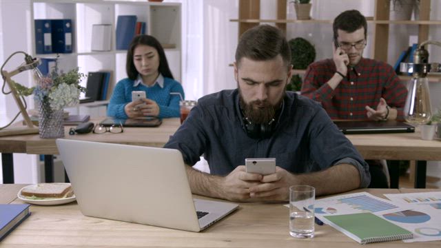Businessman using his phone in the office.