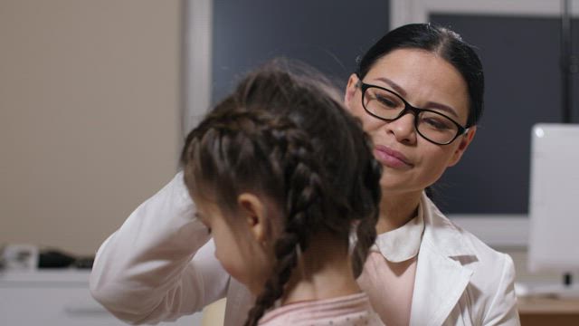 Woman examining a sick girl.