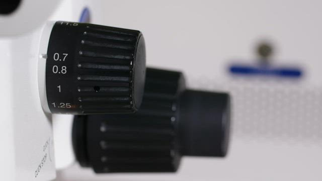 Increasing the zoom on a microscope.