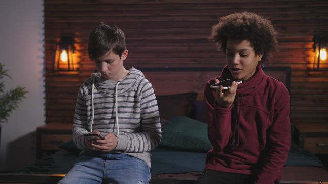 Two boys using their phones.