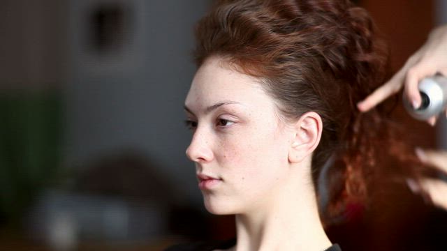 Hair styler working on a womans hair .