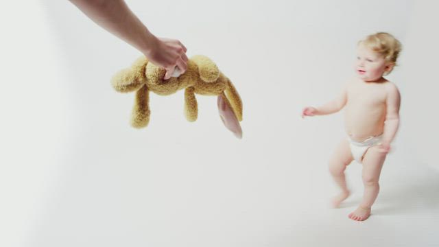 Baby trying to take a teddy.