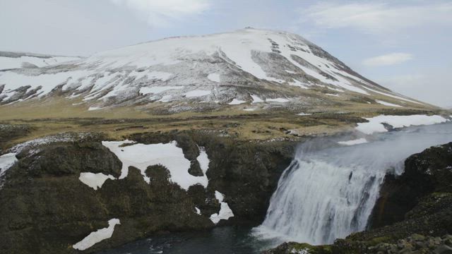 Waterfall by a mountain.