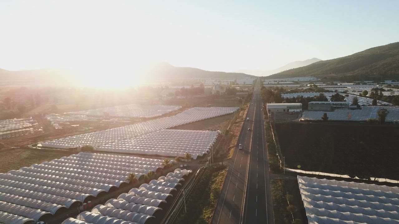 Aerial view of a road between greenhouses  - Free Stock Video