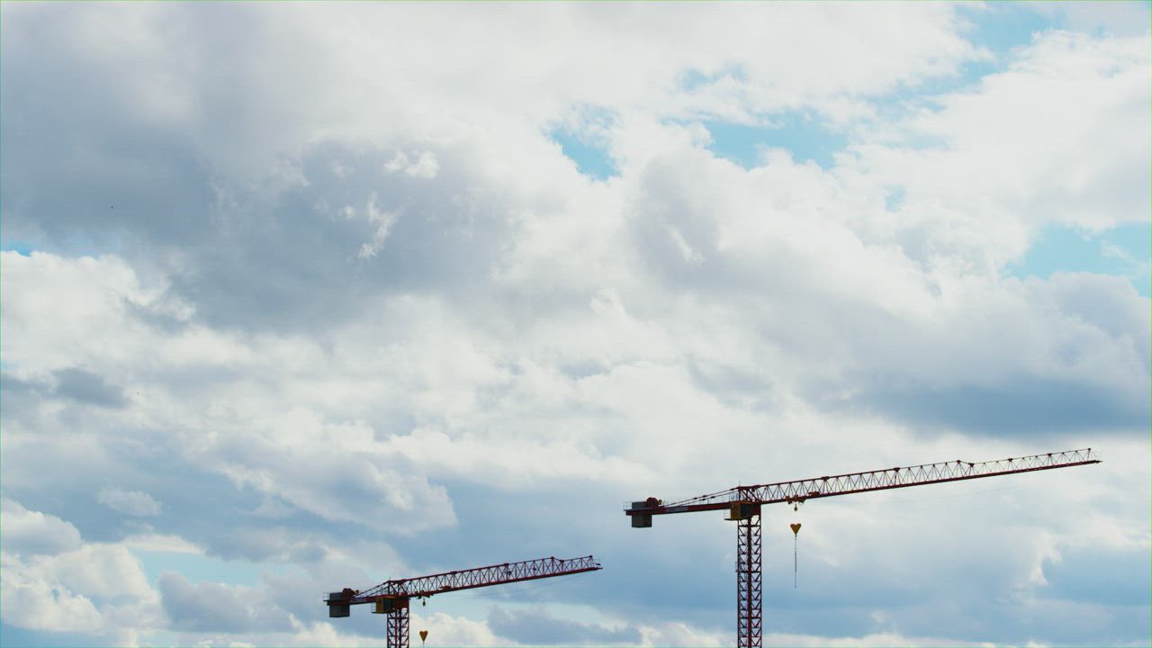 Construction crane towers under cloudy sky - Free Stock Video