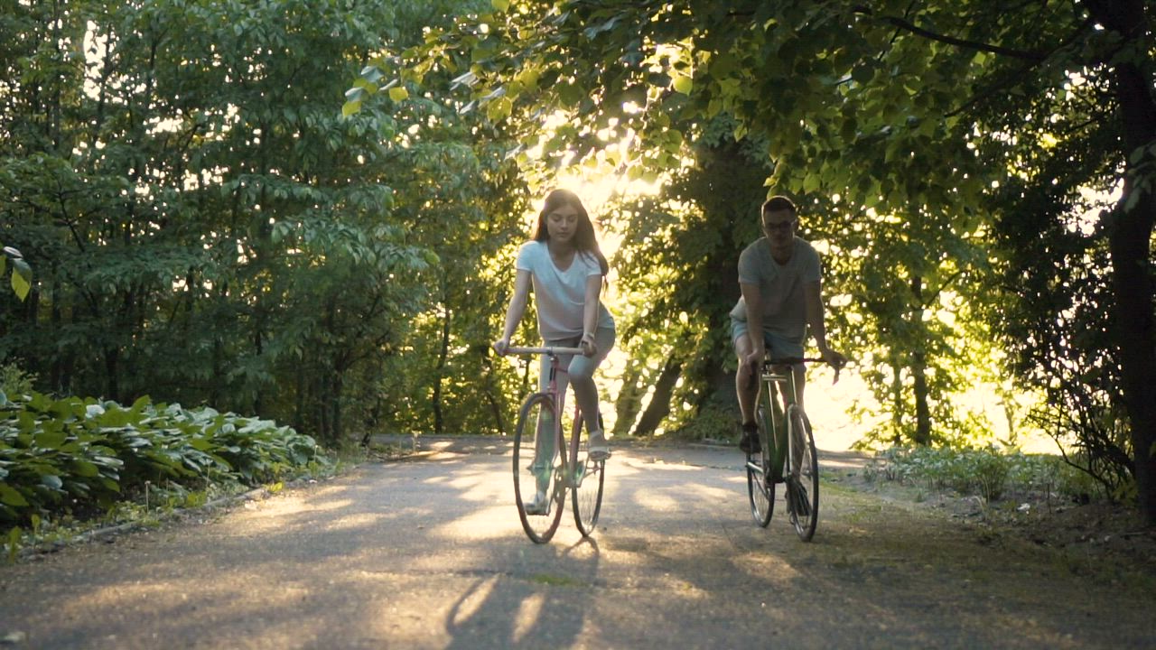 Friends enjoy sunny bike ride in park - Free Stock Video