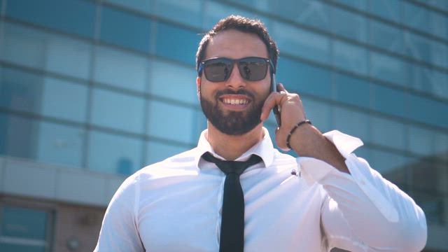 Dubai businessman in sunglasses on mobile phone.
