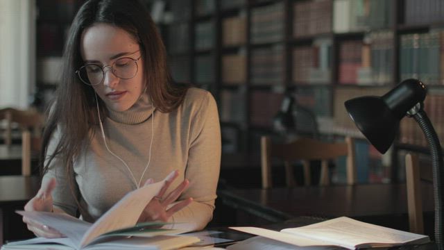 Girl studies high school education in library.