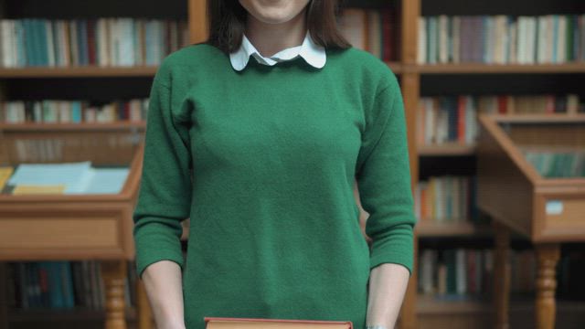 University student smiles and holds books.