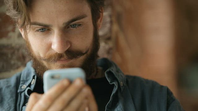 Urban man browses web on mobile phone.