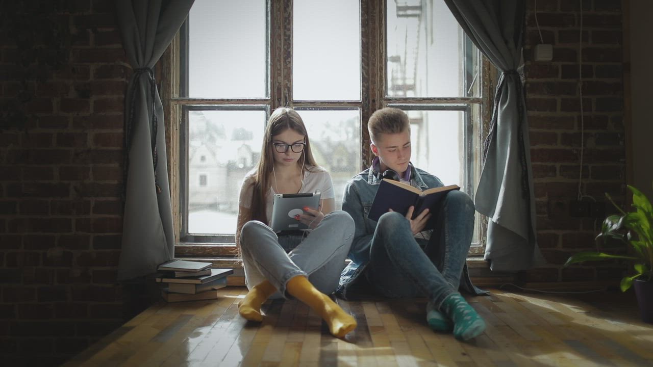 Young students helping each other study by window - Free Stock Video