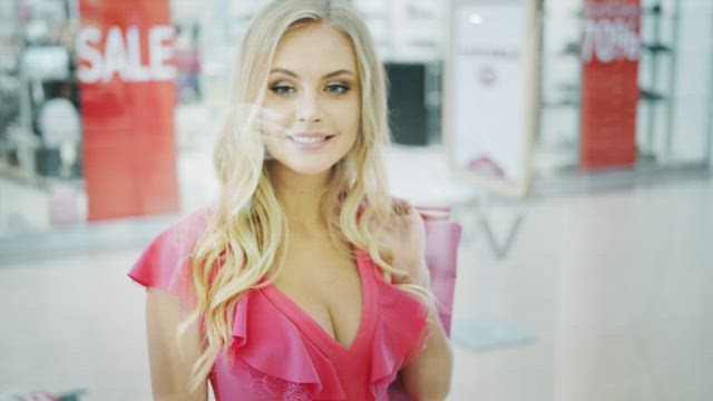 Woman looks into shopping mall showcase.