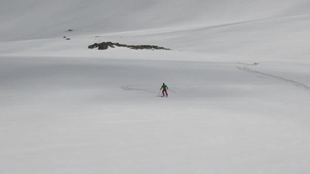 A skier descending in the snow.