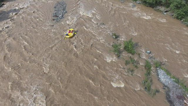 A yellow boat in the river rapids.