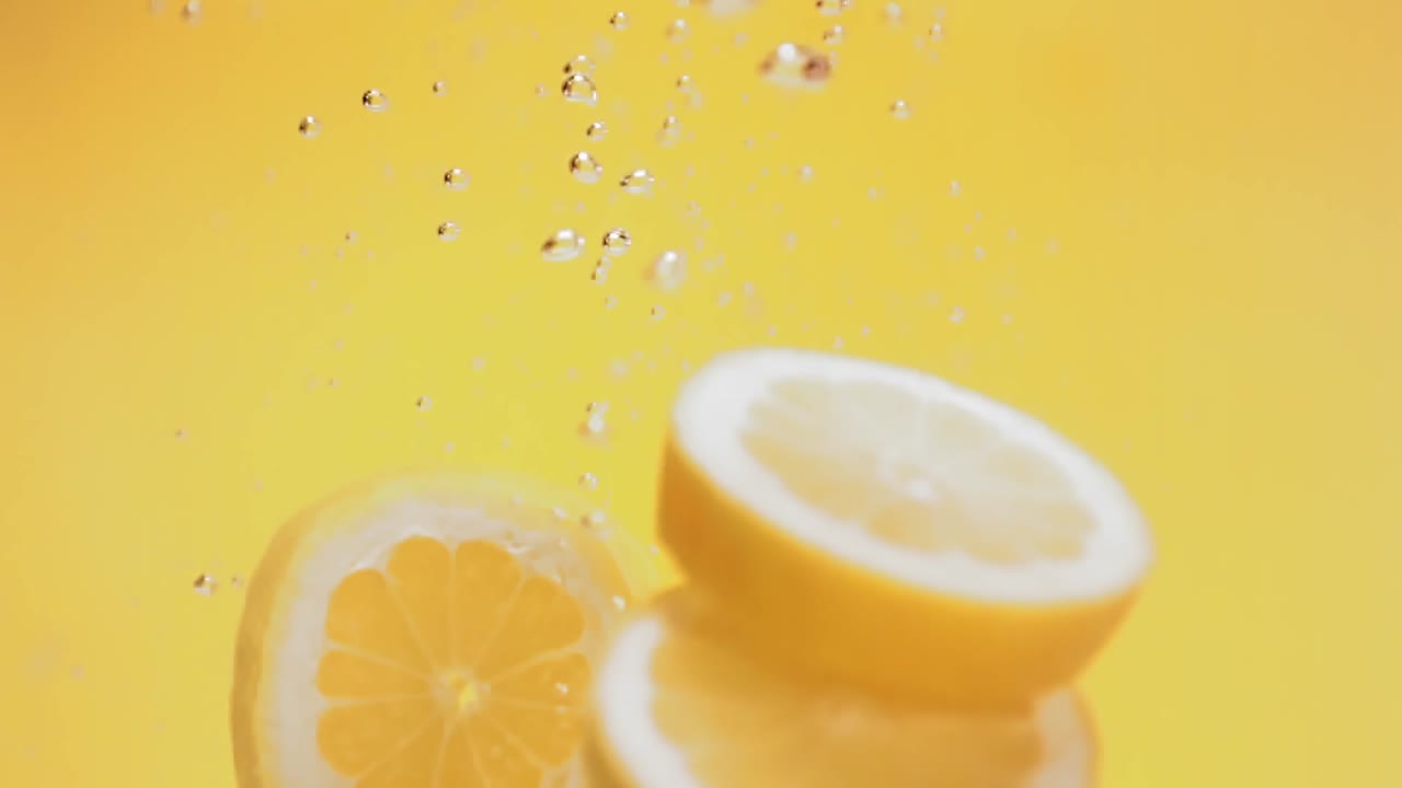 Lime Slices Splashing With Yellow Backdrop.